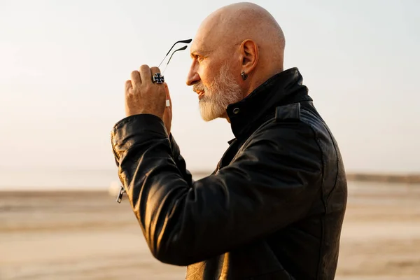 Mature Bold Man Wearing Black Leather Looking Aside While Posing — Stockfoto