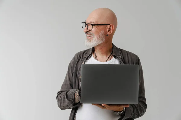 Łysy Europejczyk Okularach Uśmiechnięty Podczas Pracy Laptopem Odizolowanym Białym Tle — Zdjęcie stockowe
