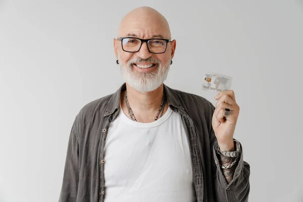 Лысый Европейский Мужчина Очках Улыбается Позируя Кредитной Картой Белом Фоне — стоковое фото