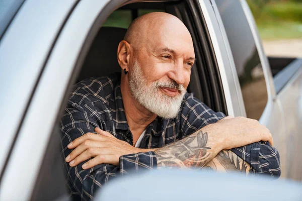 Smiling Mature White Bearded Man Looking Out Car Window Outdoors — Stockfoto