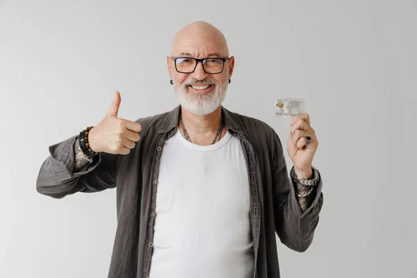 Bald European Man Eyeglasses Gesturing While Posing Credit Card Isolated — стоковое фото