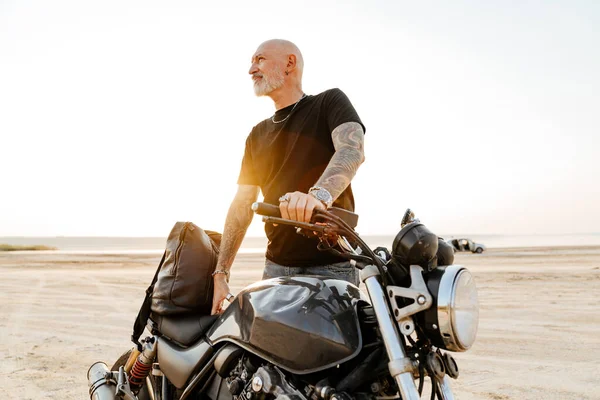 Зрілий Сміливий Чоловік Татуюванням Дивиться Вбік Позує Мотоциклі Відкритому Повітрі — стокове фото