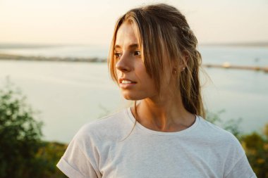 At kuyruklu beyaz bir kadın poz veriyor ve dışarı bakıyor.