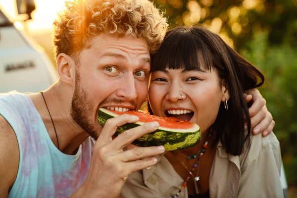 Multiracial Couple Eating Watermelon Picnic Friends Trailer Outdoors — Stockfoto