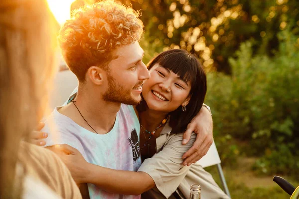Multiracial Couple Hugging Smiling Picnic Friends Outdoors —  Fotos de Stock