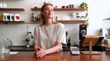 Kafenin kenarına bakan mutlu sarışın kadın.