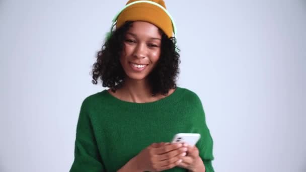Mujer Rizada Sonriente Con Sombrero Escuchando Música Auriculares Bailando Estudio — Vídeos de Stock