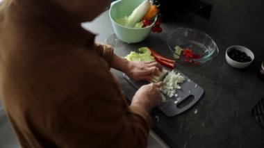 Adam evde salata için lahana kesiyor.