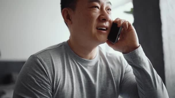 Asiatisch Positiver Mann Telefoniert Hause — Stockvideo