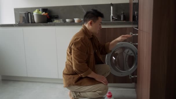 Серьезный Азиат Повседневной Одежде Включает Стиральную Машину Дома — стоковое видео