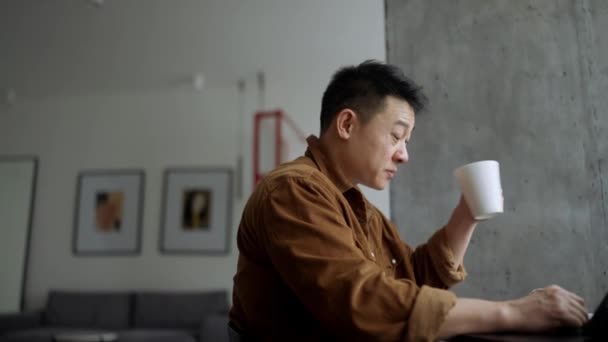 Handsome Asian Man Drinking Coffee Eating Home — Vídeos de Stock