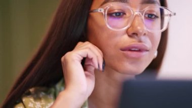 Pijama giyen gülümseyen Afrikalı kadın evde dizüstü bilgisayarla çalışıyor.