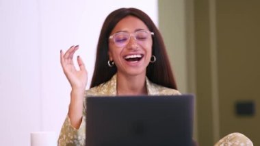 Pijama giyen mutlu Afrikalı kadın evdeki bilgisayardan video ile konuşuyor.