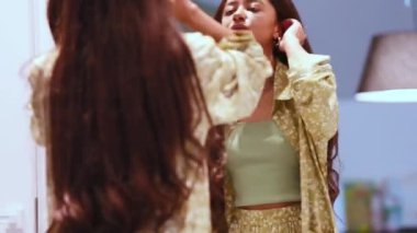 Pijama giyen yakışıklı Afrikalı kadın evdeki aynaya bakıyor.