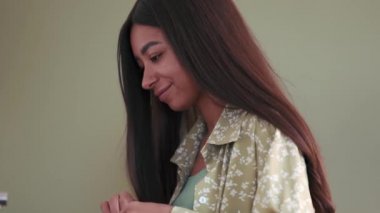 Pijama giyen güzel Afrikalı kadın evde çay demliyor.