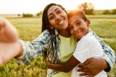 Siyah anne oğluyla yaz pikniğinde fotoğraf çekiyor.