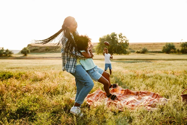 野餐时 黑人快乐的母亲和她的儿子在夏天的田里玩耍 — 图库照片