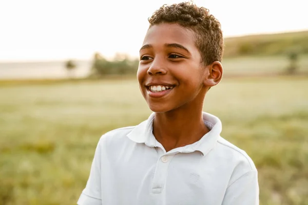 Niño Negro Vistiendo Camisa Blanca Sonriendo Mirando Lado Mientras Posa — Foto de Stock