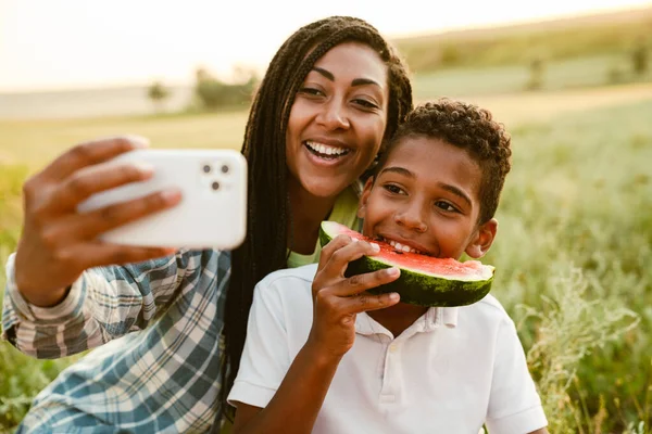 Siyah anne oğluyla yaz pikniğinde fotoğraf çekiyor.