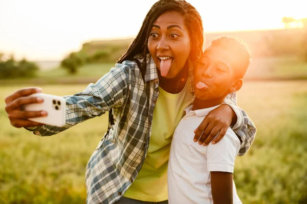 Siyah anne oğluyla yaz pikniğinde fotoğraf çekiyor.