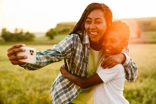 Siyah anne oğluyla yaz pikniğinde fotoğraf çekiyor.