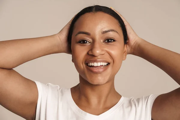 年轻的黑人妇女穿着T恤 面带微笑 把头伸出白墙外 — 图库照片