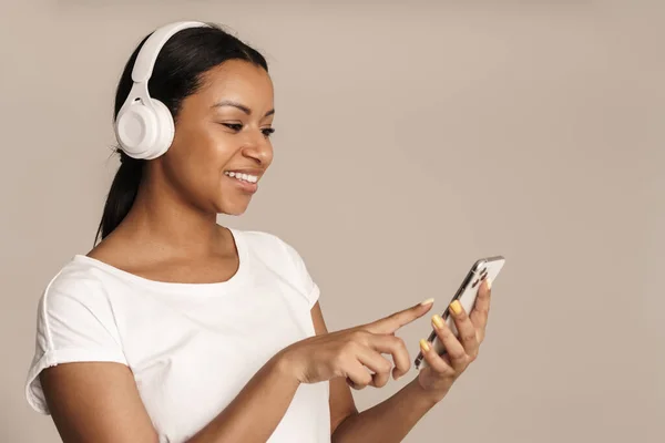 Young Black Woman Smiling While Using Cellphone Headphones Isolated White — Fotografia de Stock