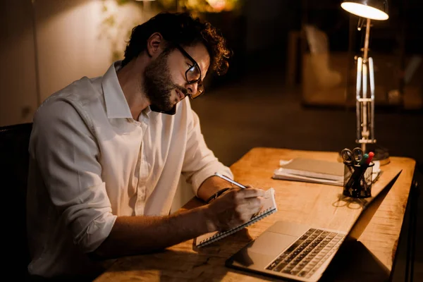 Homem Branco Óculos Falando Celular Enquanto Trabalhava Com Laptop Escritório — Fotografia de Stock