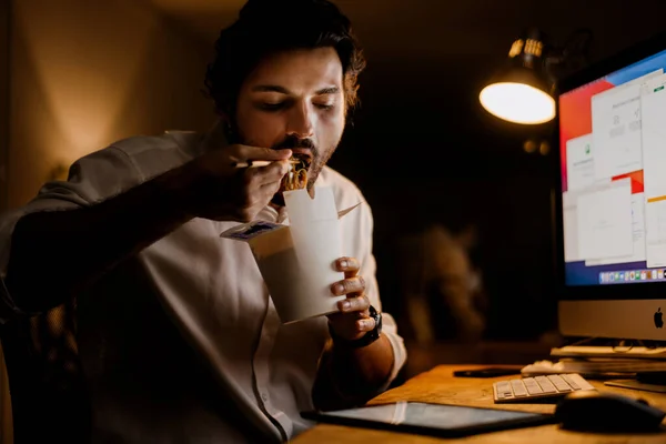 Λευκός Που Τρώει Ασιατικά Νουντλς Ενώ Δουλεύει Υπολογιστή Στο Γραφείο — Φωτογραφία Αρχείου