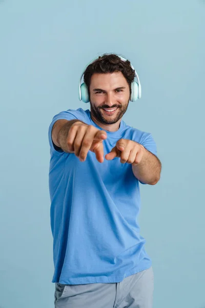 Young Brunette Man Headphones Pointing Fingers Camera Isolated Blue Background — ストック写真