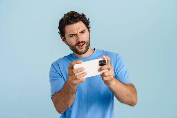 Jonge Brunette Man Spelen Online Spel Mobiele Telefoon Geïsoleerd Blauwe — Stockfoto