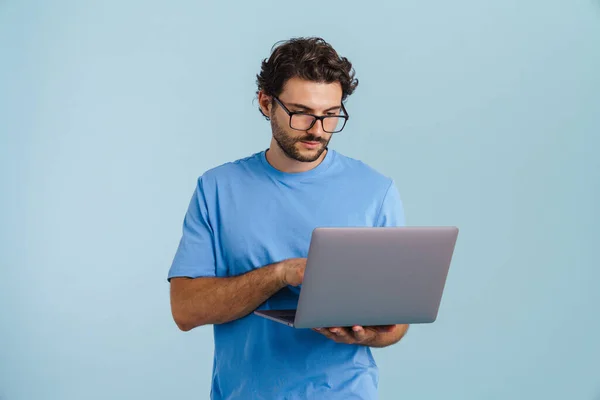 Young Brunette Man Eyeglasses Using Laptop While Posing Camera Isolated — Stockfoto