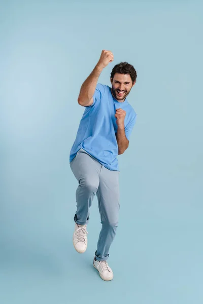 Young Brunette Man Screaming While Making Winner Gesture Isolated Blue — Stock Fotó