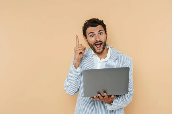 Young White Man Pointing Finger Upward While Holding His Laptop — стоковое фото