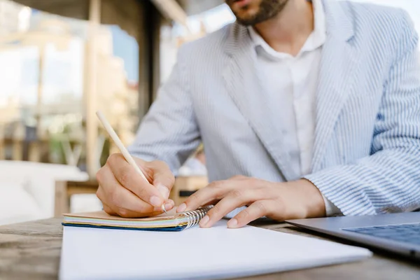 Young Man Wearing Jacket Writing Notes While Working Laptop Cafe — Stockfoto