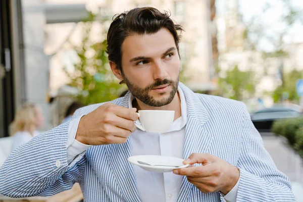 Νεαρός Μελαχρινός Άνδρας Πίνοντας Καφέ Ενώ Κάθεται Στο Καφέ Έξω — Φωτογραφία Αρχείου
