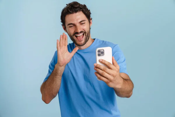 Young Brunette Man Gesturing While Using Mobile Phone Isolated Blue — Foto de Stock