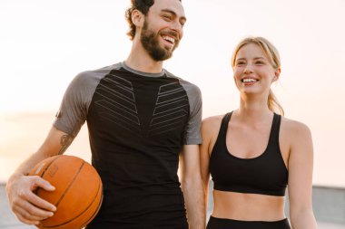 Genç bir adam ve bir kadın dışarıda birlikte top oynuyorlar.