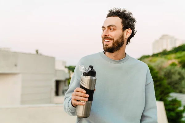 Ung Man Ler Och Dricker Vatten När Tränar Parkering Utomhus — Stockfoto