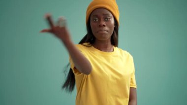 Turkuaz stüdyoda dans eden yakışıklı Afrikalı kadın.