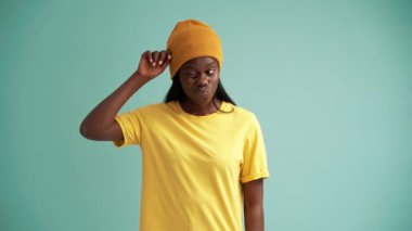 Turkuaz stüdyoda ellerini açan güzel Afrikalı kadın.