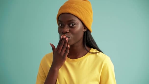 Sonriente Mujer Africana Soplando Aire Beso Cámara Estudio Color Turquesa — Vídeos de Stock