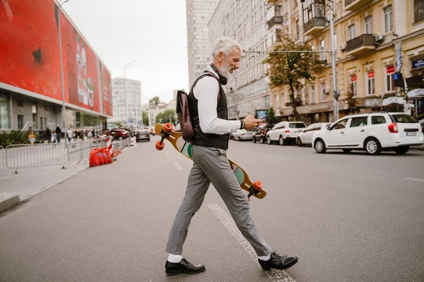 Grey Mature Man Using Mobile Phone While Walking Skateboard City — Foto Stock