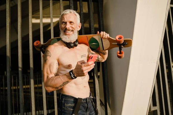 Adult White Shirtless Man Holding Cellphone While Standing Skateboard His — Foto Stock