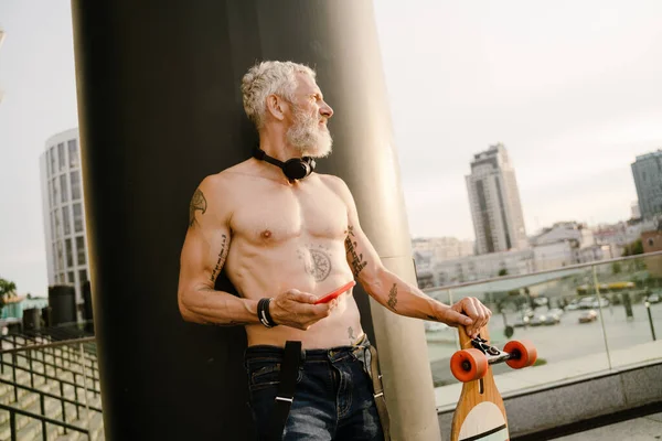 Shirtless Mature Man Using Cellphone While Standing Skateboard City Street — Foto Stock