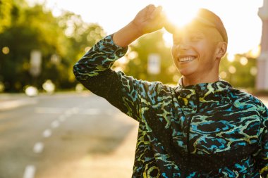 Genç sporcu dışarıda çalışırken gülümsüyor.