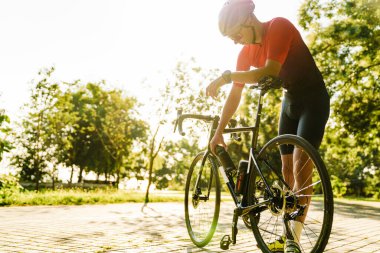 Yeşil Park 'ta çalışan kasklı genç beyaz bisikletçi.