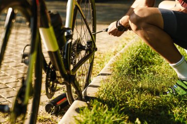 Green Park 'ta spor yaparken lastiği şişen genç beyaz bisikletçi.