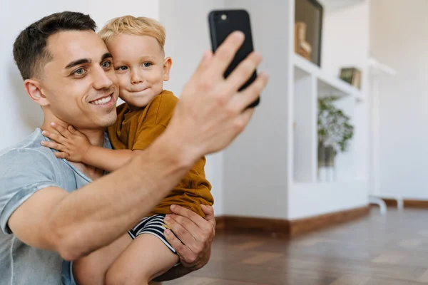 Young Father Son Smiling Taking Selfie Photo Mobile Phone Home — Fotografia de Stock
