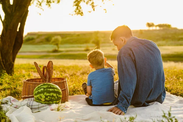 Genç beyaz baba oğluyla yaz sahasında piknik yapıyor.